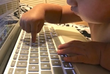 Image of baby pressing a computer key.