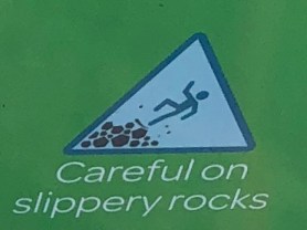 Image of person slipping on rocks with the caption "Careful on Slippery Rocks."