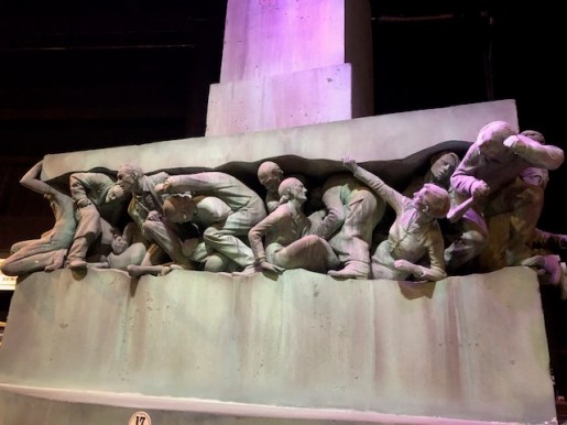 Image of sculpture of muggle being crushed.